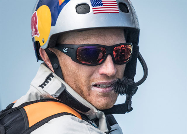 Dressed in a silver helmet with the US flag on it it America's cup skipper Jimmy Spithill