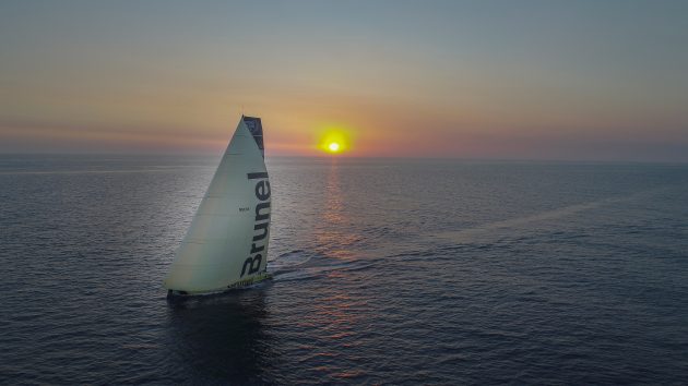 A Volvo Ocean Race yacht sailing into the sunset