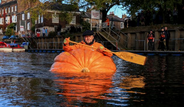 Tom Pearcy rowing a pumpkin boat down the River Ouse in York
