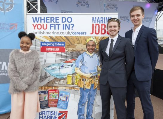 girl and three man standing by a sign